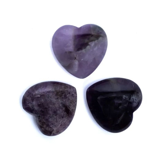 Three heart-shaped purple stones on a white background