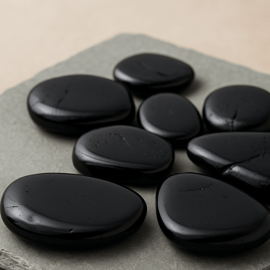Black tourmaline stones on a gray stone surface