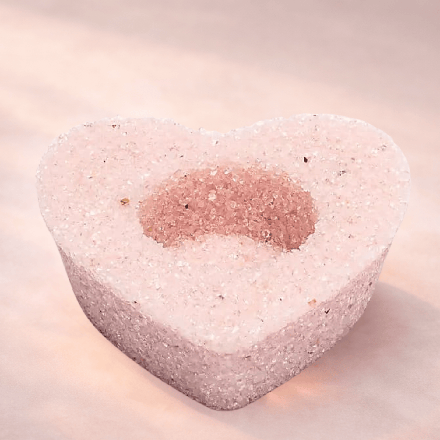 Heart-shaped Rose Quartz candle holder for tealights on a light background