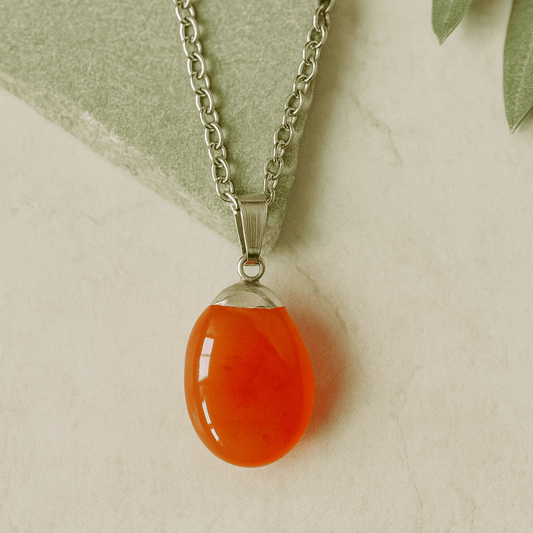 Necklace with a teardrop-shaped orange pendant on a light background