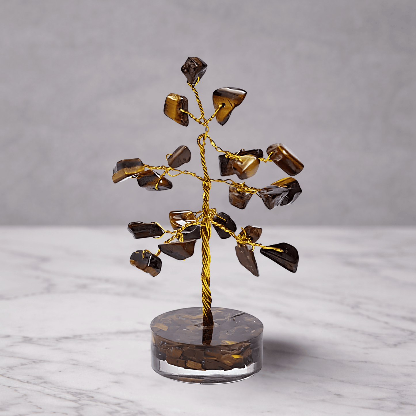 Decorative tree sculpture with brown and gold elements on a marble surface