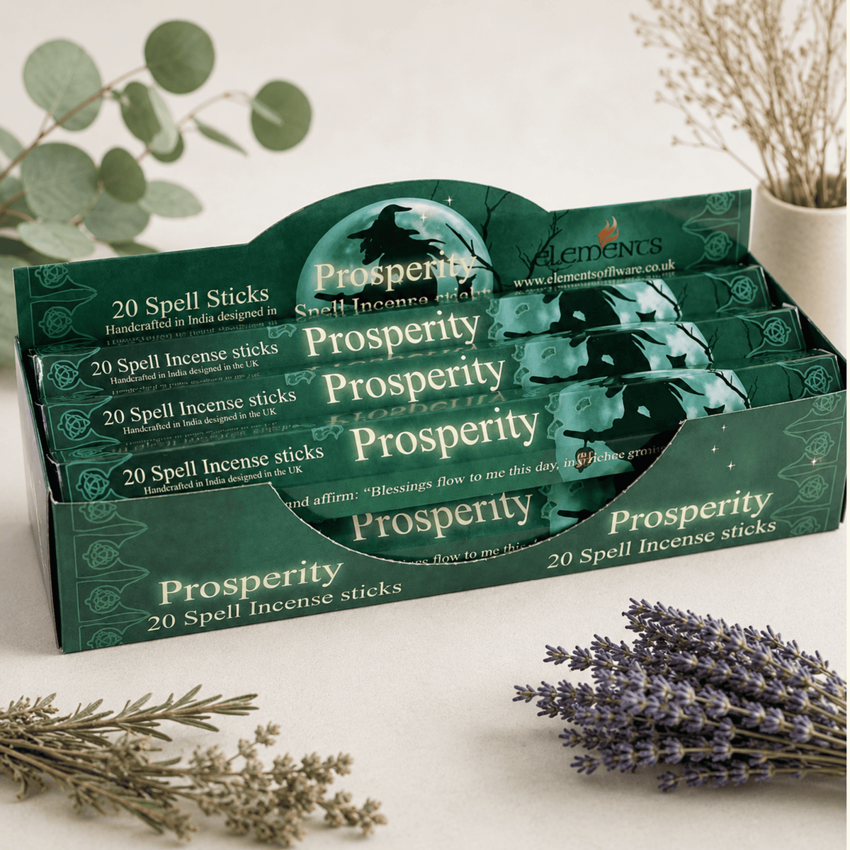 Display of 'Prosperity' spell incense sticks packaging with lavender and herbs on a light background