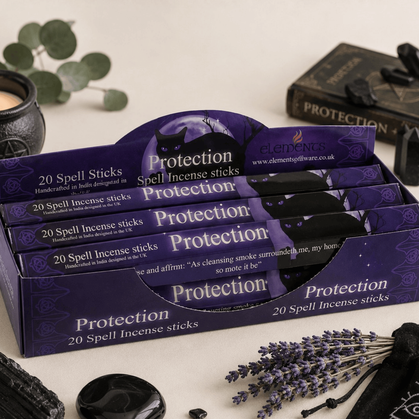 Display of 'Protection' spell incense sticks packaging with lavender and black stones on a neutral background.
