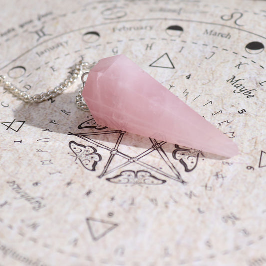 Pink rose quartz crystal on an astrological chart with symbols and text.