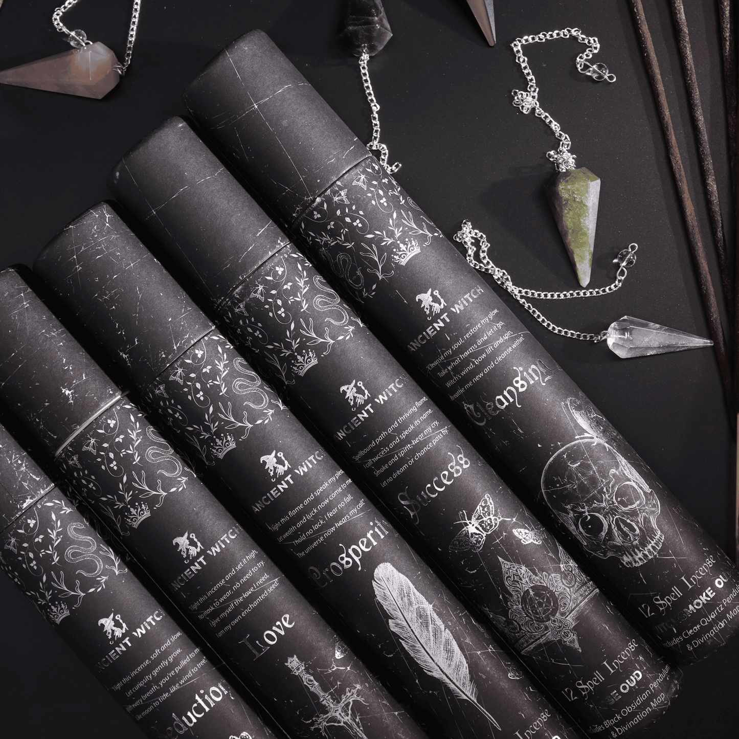 Black cylindrical containers with decorative labels on a dark surface with crystals and jewelry.