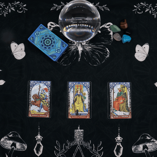 Tarot cards, crystal ball, and decorative elements on a black tarot cloth, decorated wth graphics
