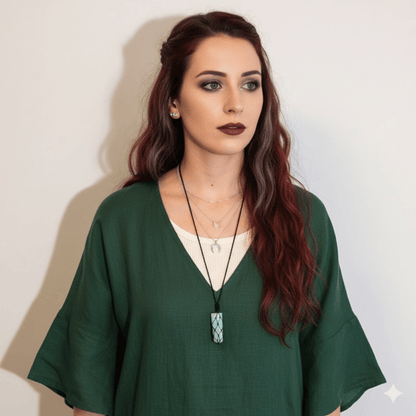 Woman wearing a green top with a Amazonite necklace against a plain background