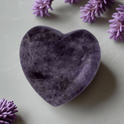 Heart-shaped purple stone with lavender flowers on a light surface