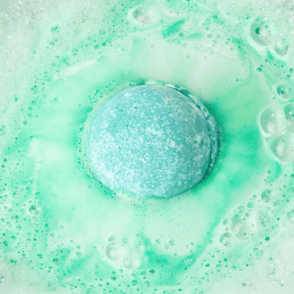 Green bath bomb fizzing in water