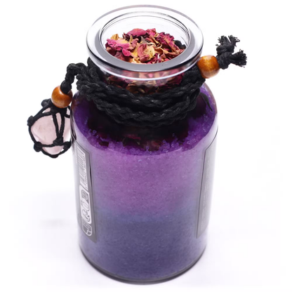 Purple glass jar with dried flowers on a white background