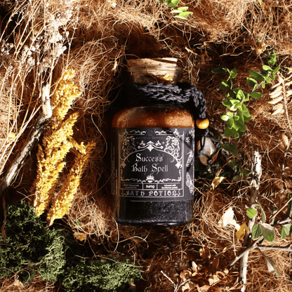 Jar labeled 'Success Bath Spell' surrounded by natural elements on a textured surface