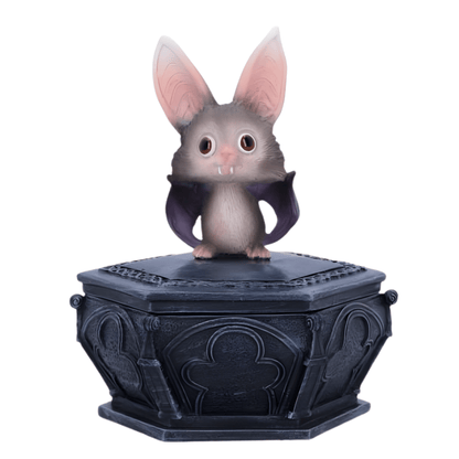 Small bat creature with large ears on a decorative black base against a white background