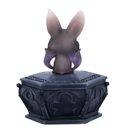 Back of a bat creature on a decorative black base with intricate designs