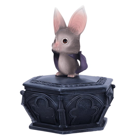 Small gray bat figurine with a purple bow on a black decorative base against a white background