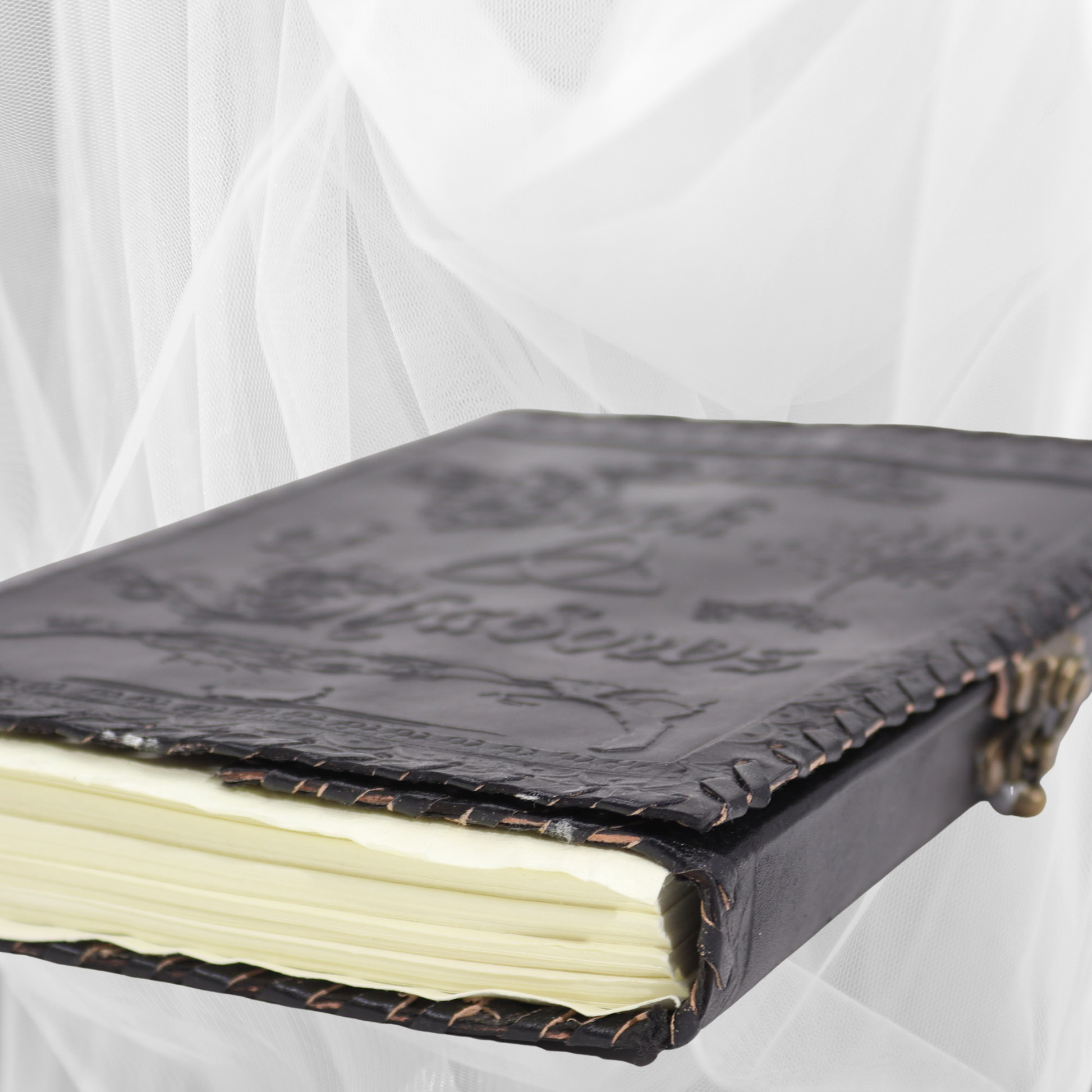 Vintage leather-bound book with embossed design on a white background