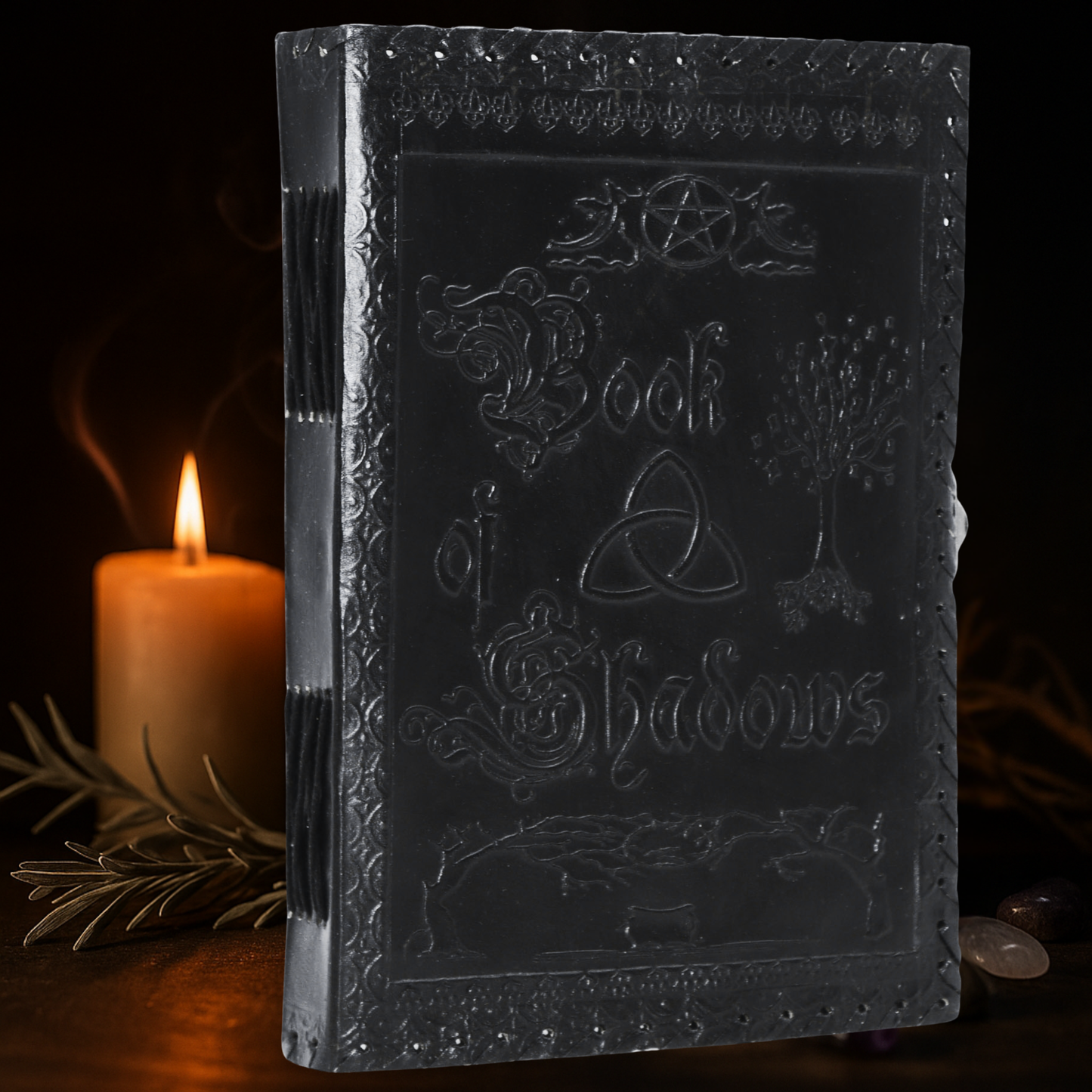 Dark leather-bound book titled 'Book of Shadows' with a candle in the background