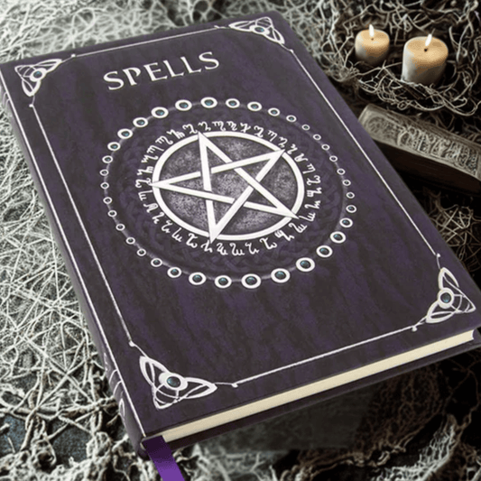 Purple spellbook with a pentagram design on a textured surface with candles.