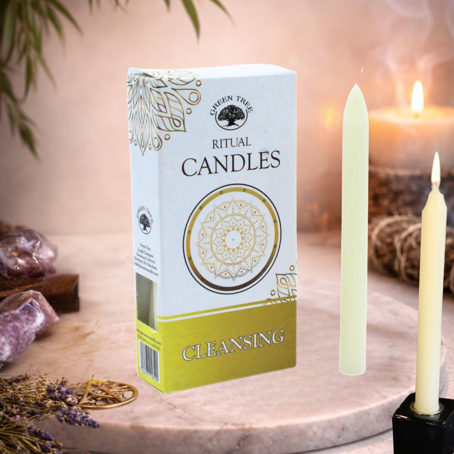 Box of ritual candles labeled 'Cleansing' with two candles on a decorative surface.
