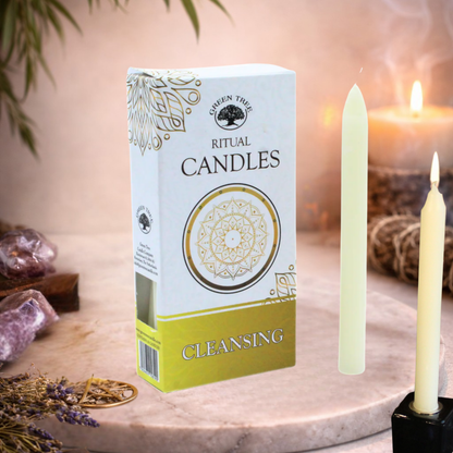 Box of ritual candles labeled 'Cleansing' with two candles on a decorative surface.