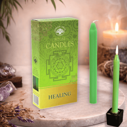 Green ritual candles with packaging on a decorative surface