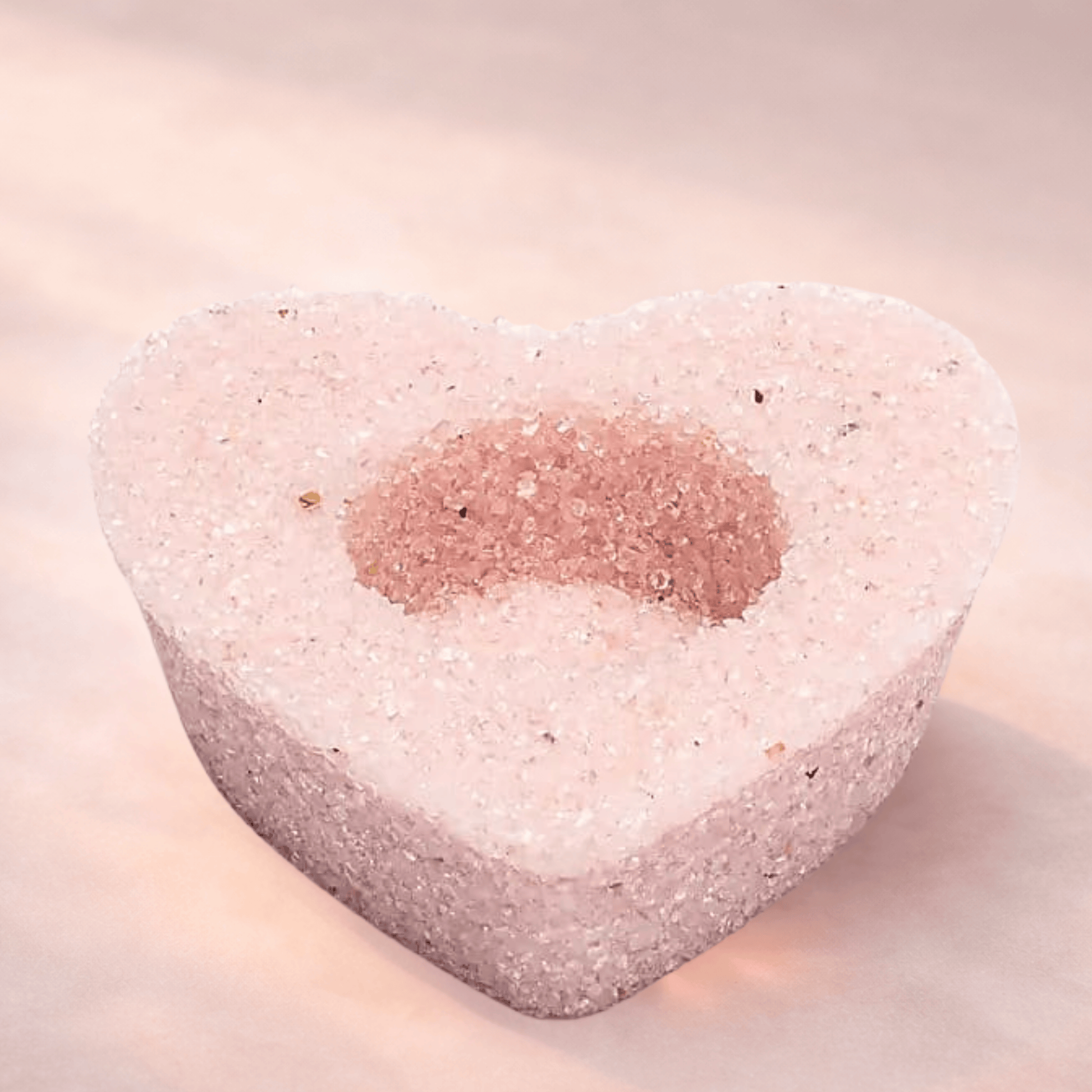 Heart-shaped Rose Quartz candle holder for tealights on a light background