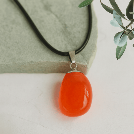 Necklace with an orange pendant on a light background