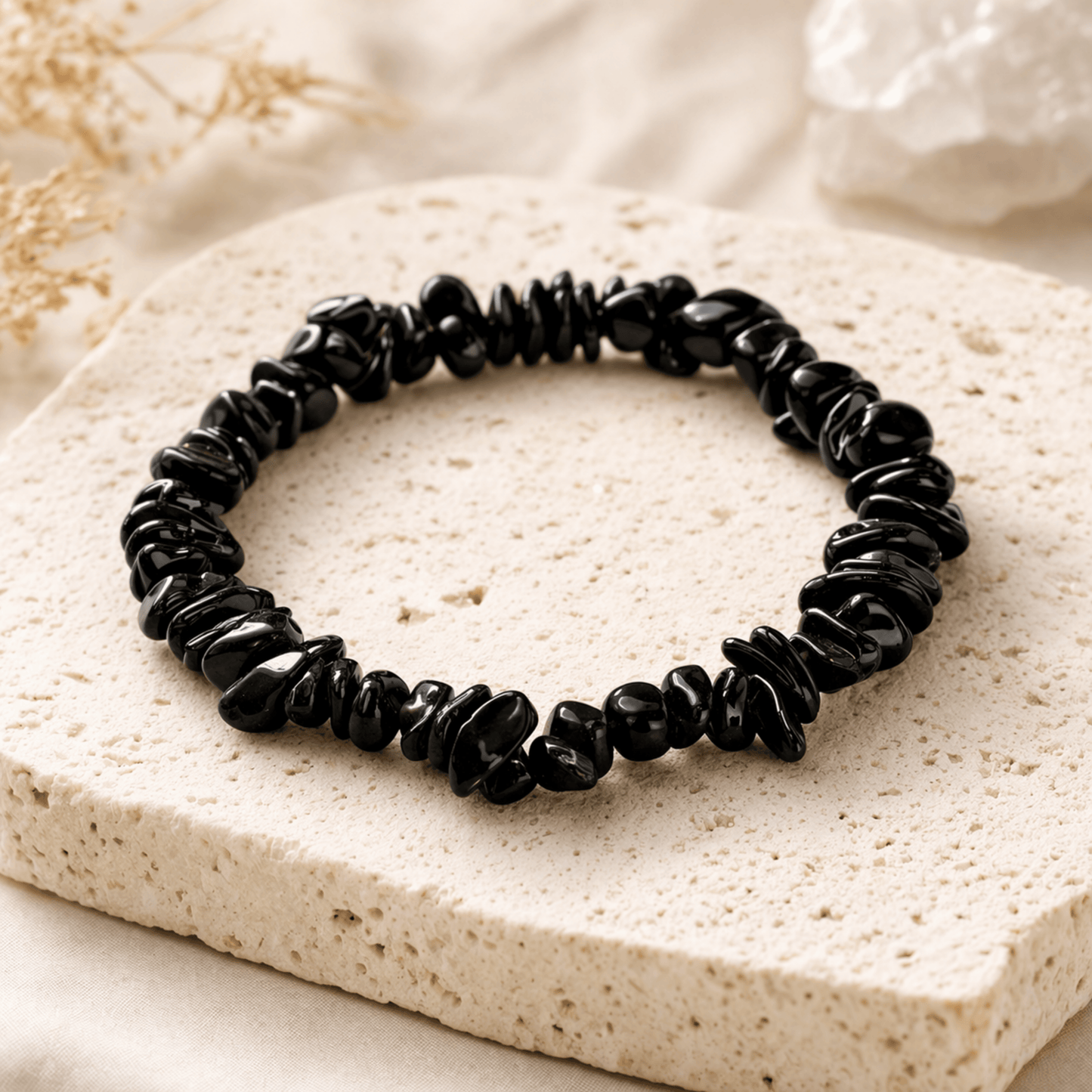 Black Crystal smooth chips bracelet on a cream coloured stone