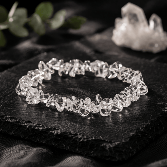 Clear Quartz clear chipstone elastic bracelet on a black square stone with green leaves and rock crystal in the background
