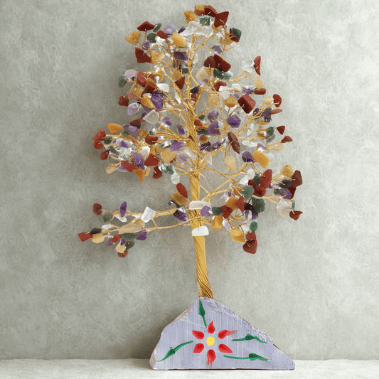 Decorative tree sculpture with multicolored stones on a textured gray background