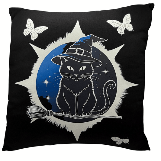 Black pillow with a cat wearing a witch hat, broom, and star design on a black background.