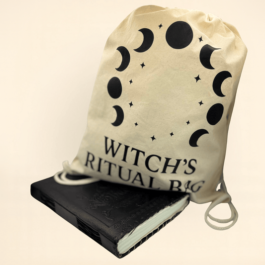 Beige drawstring bag with moon phase design and 'Witch's Ritual Bag' text, next to a black book of shadows beige background.