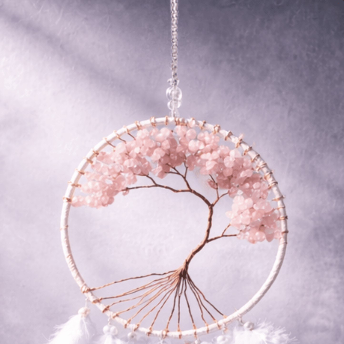 Decorative wall hanging with pink beads and gold wire on a gray background