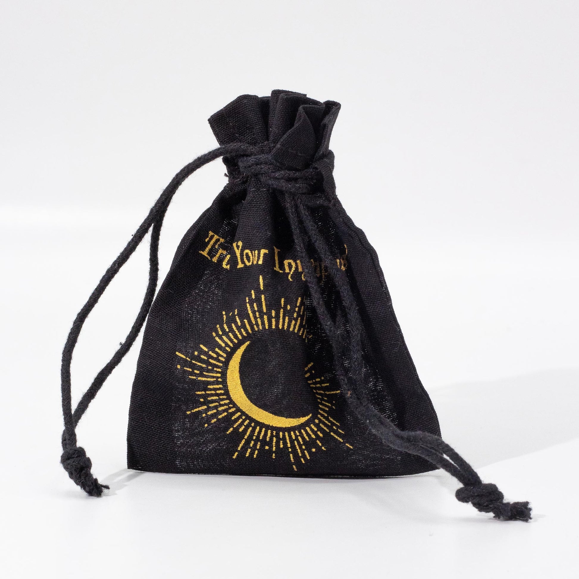 Black drawstring bag with gold crescent moon and text design on a white background