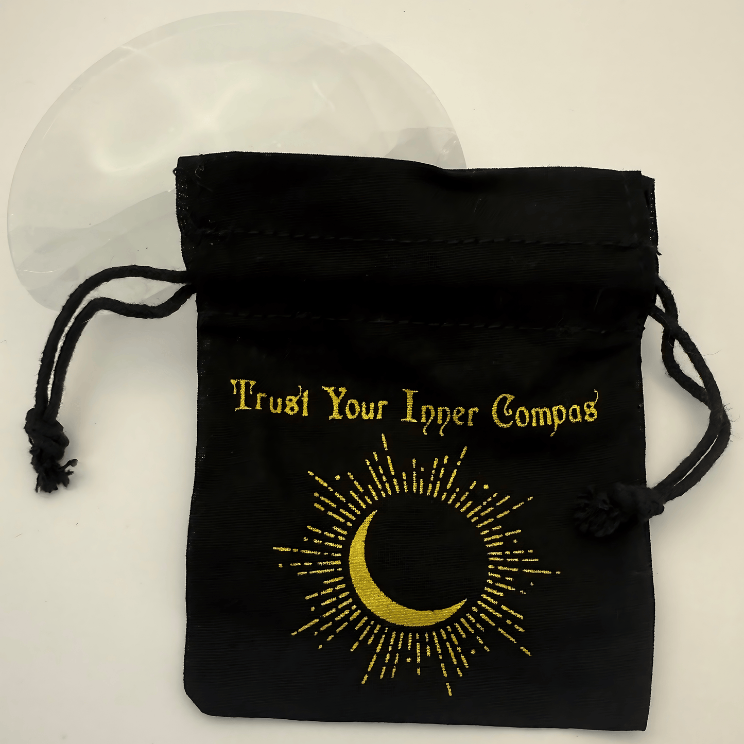 Black drawstring pouch with gold text and crescent moon design on a white background