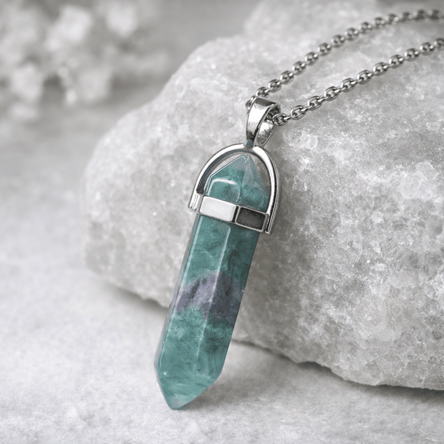 Crystal pendant necklace on a stone surface