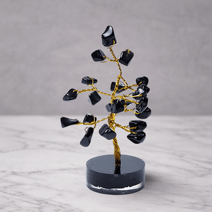 Black agate crystal gemstone tree with dark polished stones on a decorative base, used for grounding, protection and calming feng shui home decor
