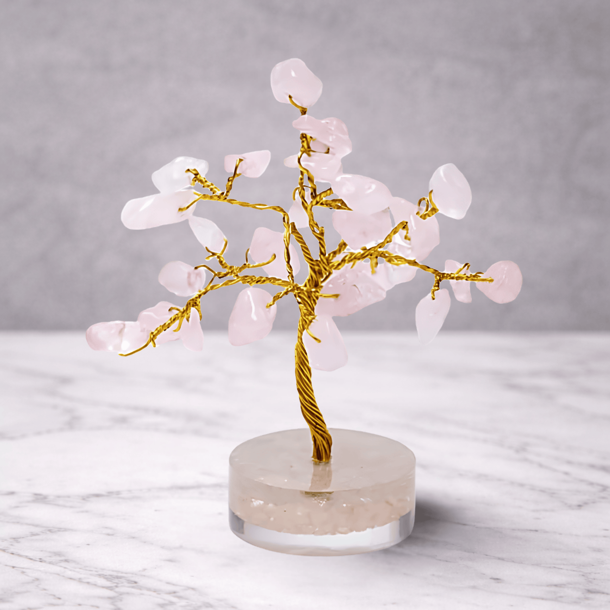 Rose quartz crystal gemstone tree with soft pink stones on a decorative base, used for love, healing energy and calming feng shui home decor