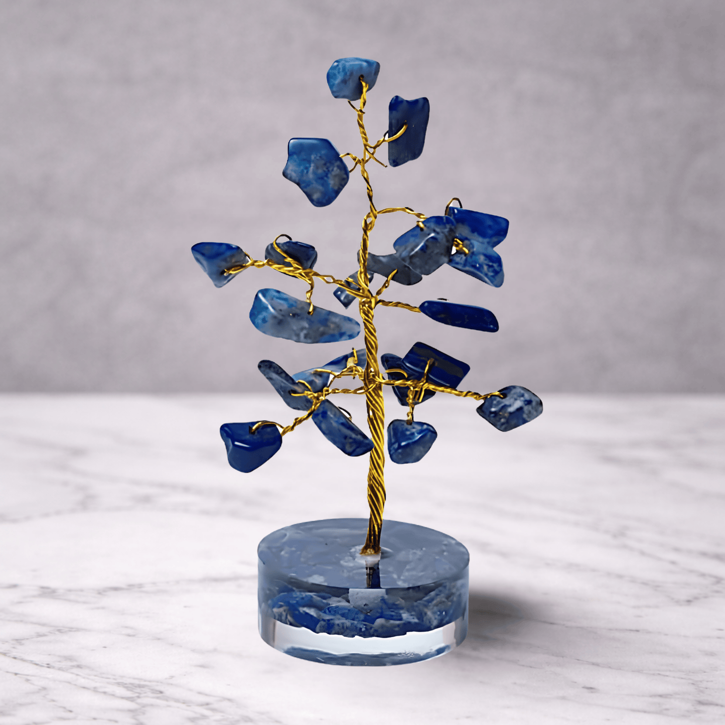 Decorative tree sculpture with blue stone leaves on a gray background