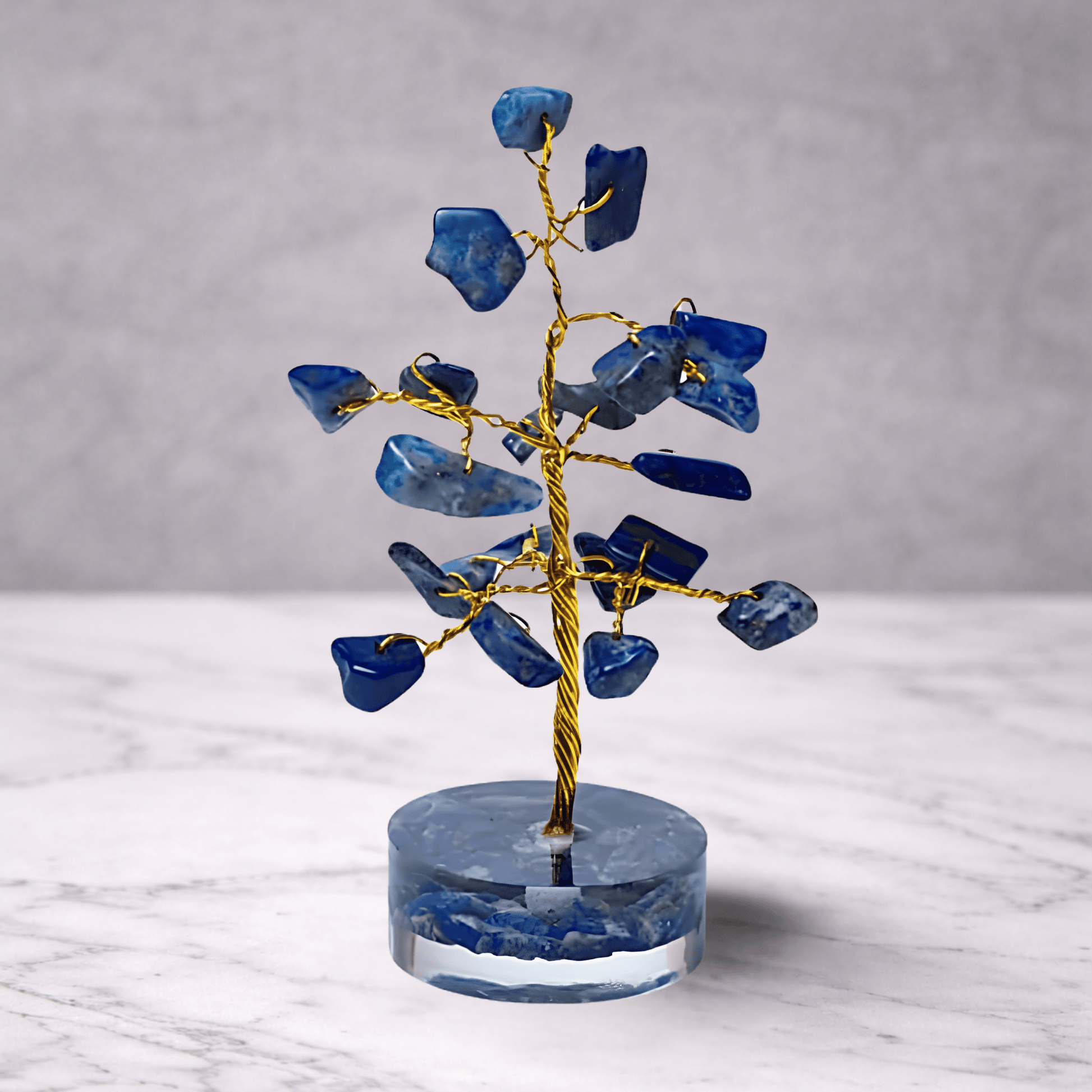 Decorative tree sculpture with blue stone leaves on a gray background
