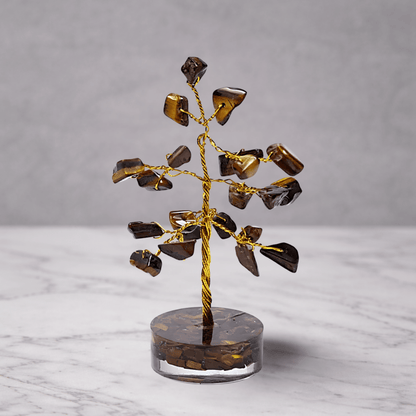 Decorative tree sculpture with brown and gold elements on a marble surface