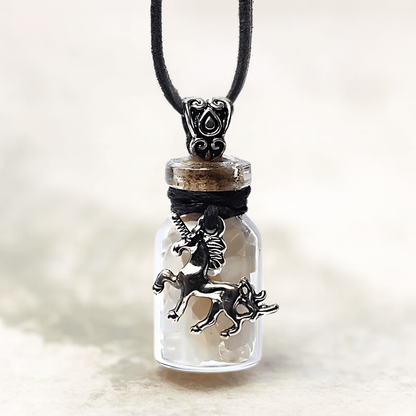 Unicorn charm in a glass bottle pendant on a blurred background