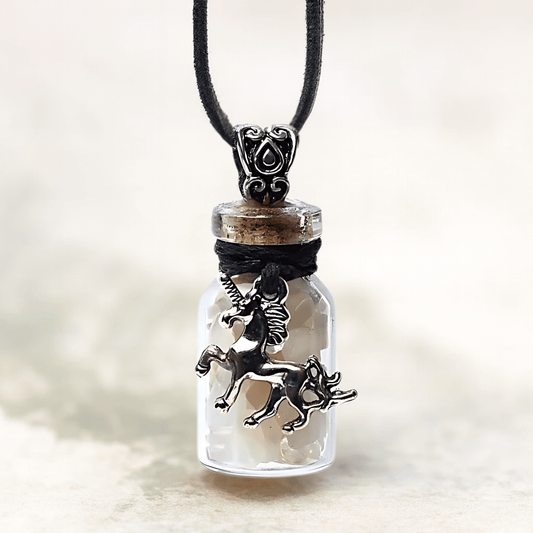 Unicorn charm in a glass bottle pendant on a blurred background