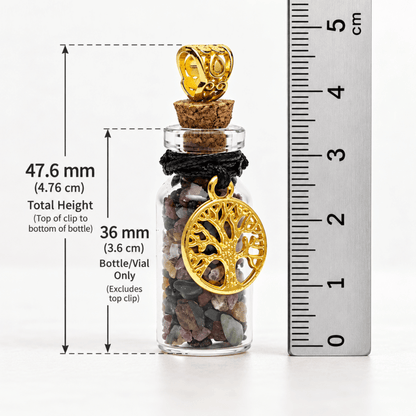 A small clear glass vial with a cork stopper, filled with multicolored pebbles, featuring a gold tree-of-life pendant and black cord wrap. Measurement annotations show total height of 47.