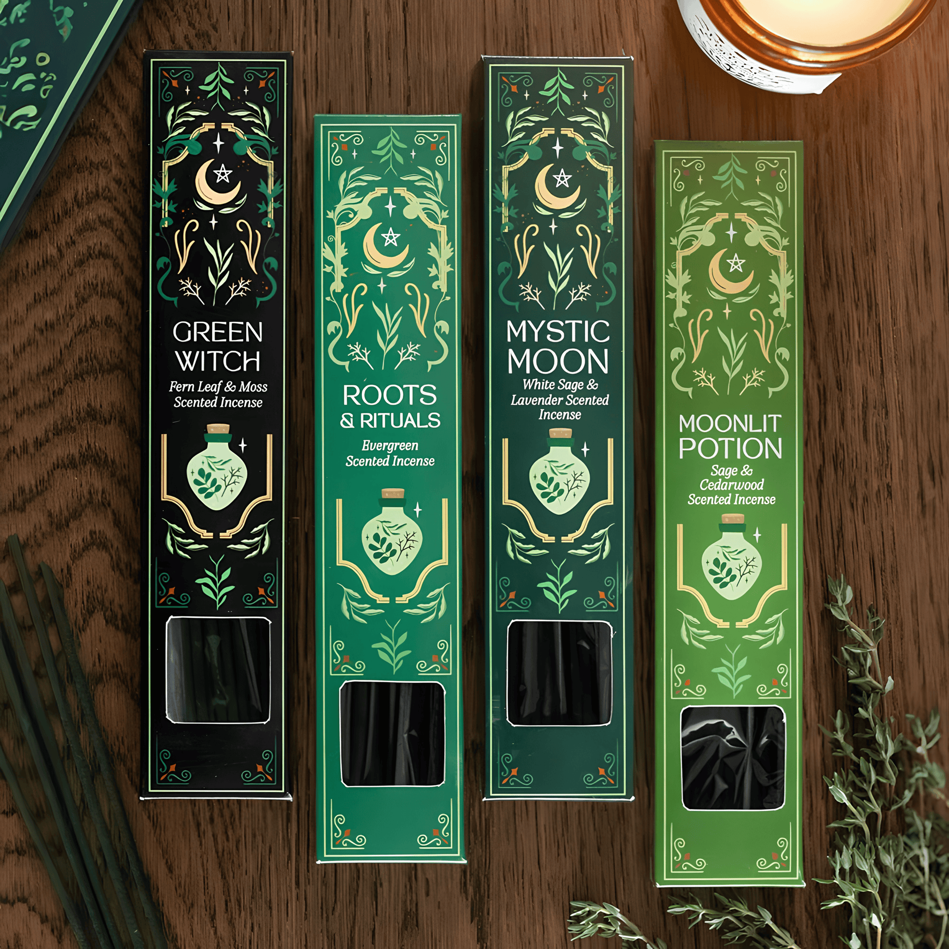 Four tall rectangular scented incense boxes arranged on a wooden surface, each with ornate green and gold illustrated packaging and visible incense sticks through a window near the bottom. The box labels read Green Witch, Roots & Rituals, Mystic Moon, and Moonlit Potion.