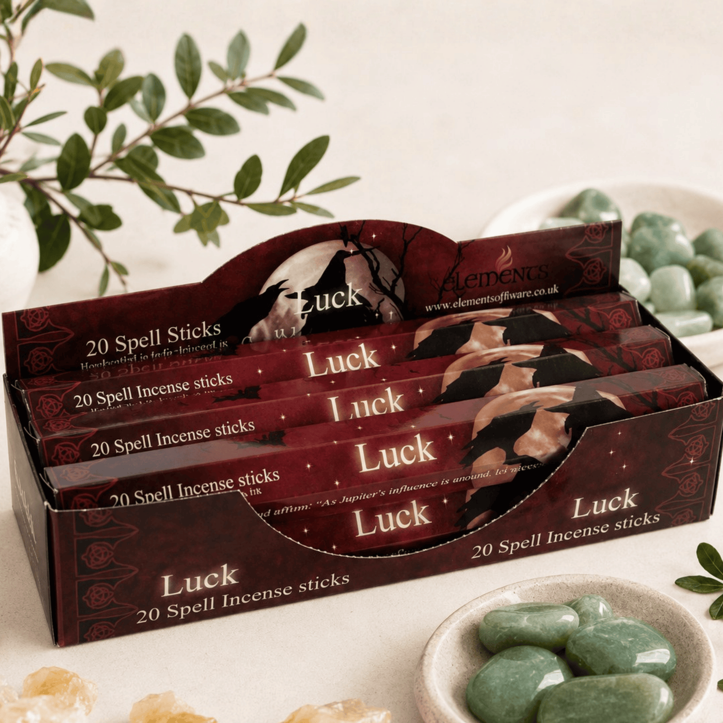 Box of Luck spell incense sticks with green stones and leaves in the background