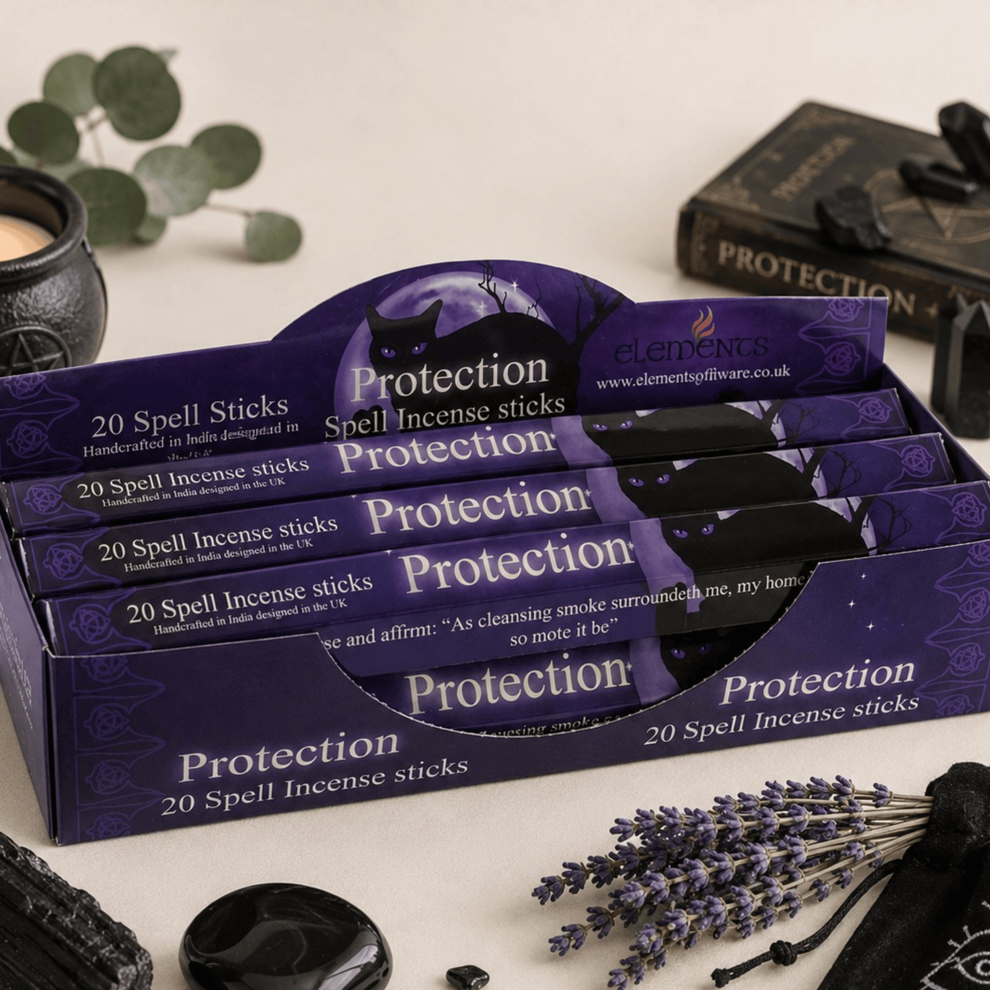 Display of 'Protection' spell incense sticks packaging with lavender and black stones on a neutral background.