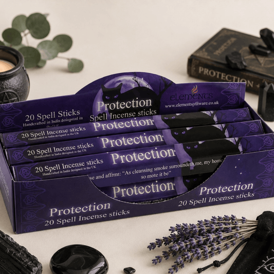 Display of 'Protection' spell incense sticks packaging with lavender and black stones on a neutral background.