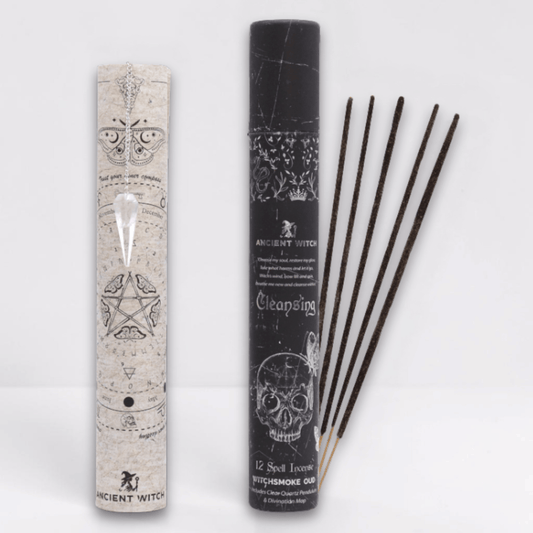 Incense sticks with packaging featuring mystical designs on a white background and a white pointed crystal attached to a silver chain draped over a paper map.