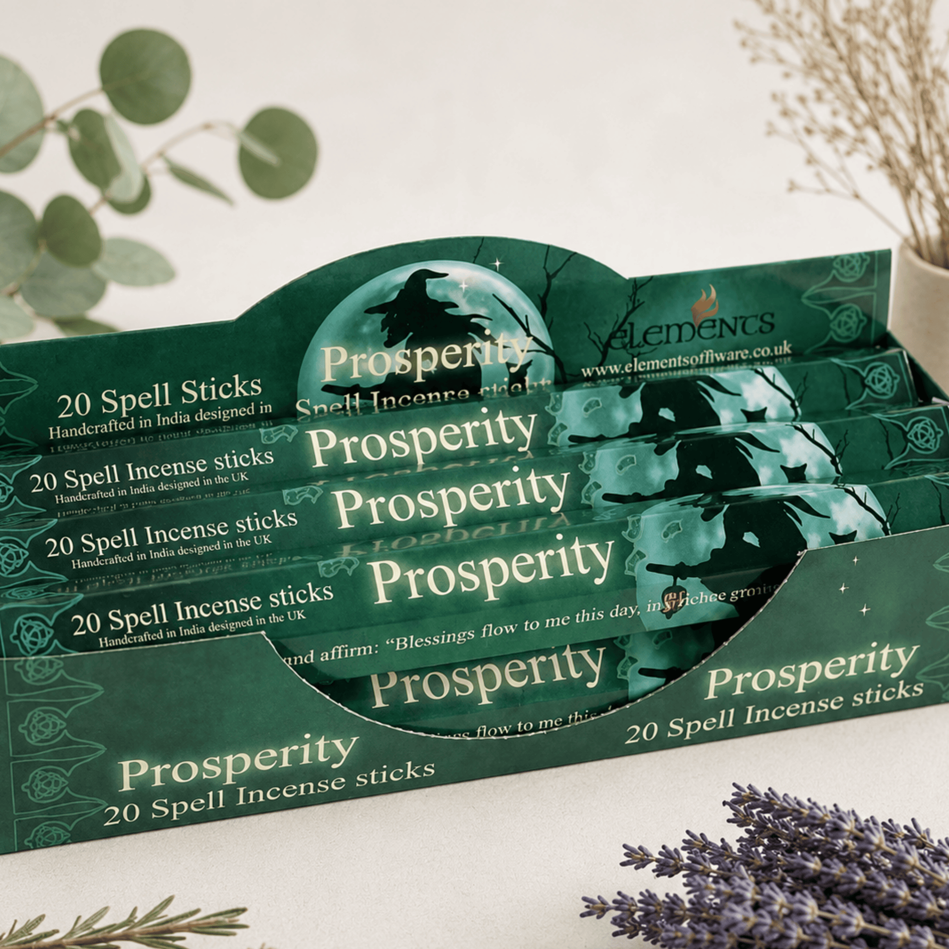 Display of 'Prosperity' spell incense sticks packaging with lavender and herbs on a light background