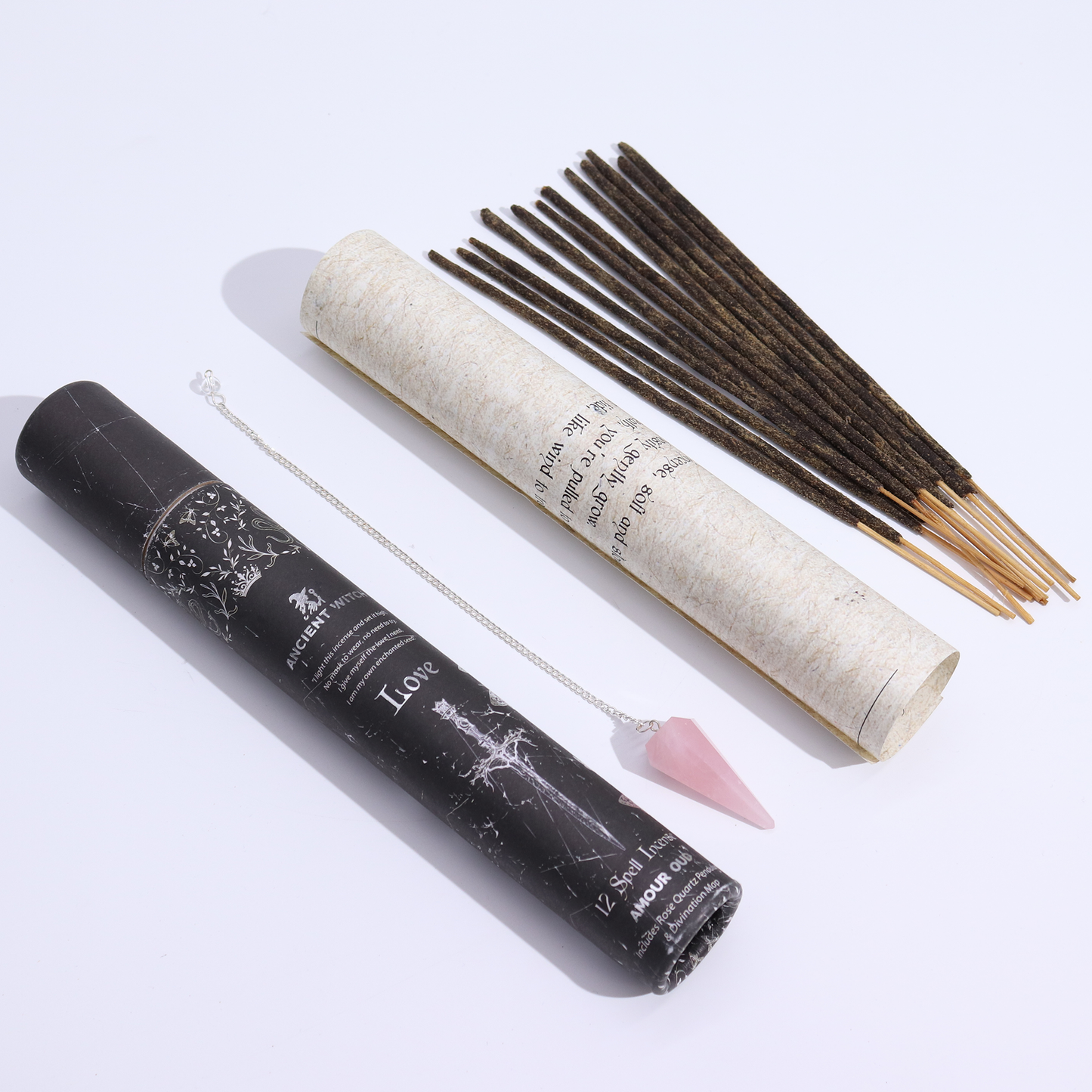 Incense sticks with a roll of incense, pendulum, and amulet on a white background